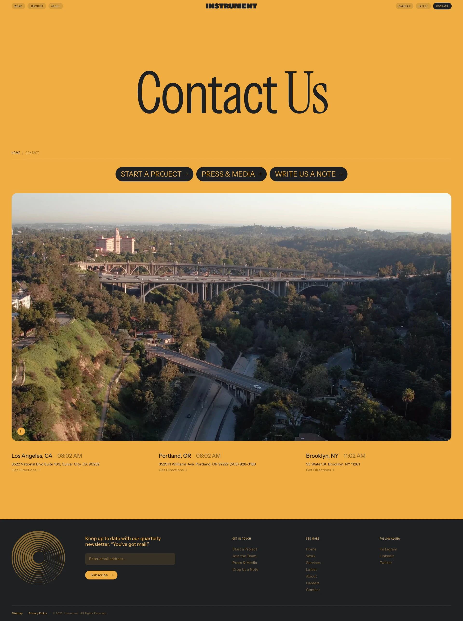 Contact page with oversized serif headline, three rounded black buttons, and a wide landscape photo.